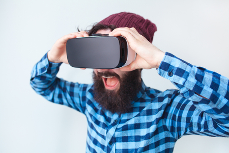 Cheerful man adjusting VR gogglesの写真素材