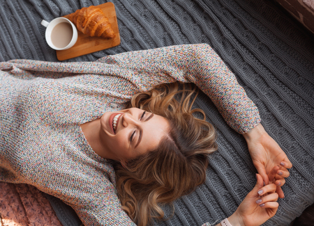 Cheerful woman on bedの写真素材