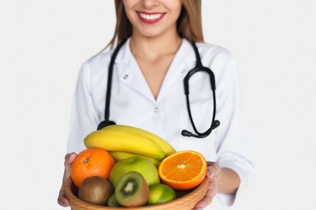 Anonymous doctor posing with fruitsの写真素材