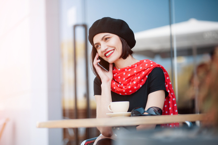 Smiling woman talking phone outsideの写真素材