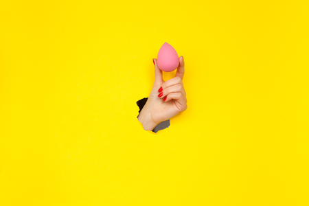 Crop female hand holding beauty blenderの写真素材