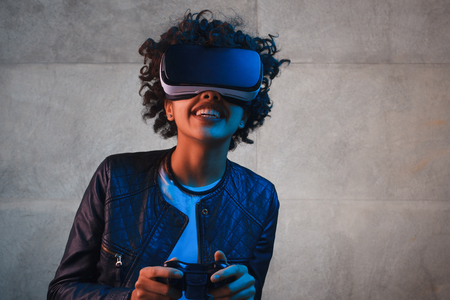 Smiling woman with gamepad and VR gogglesの写真素材