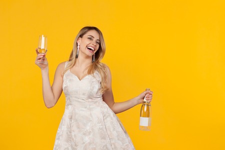 Cheerful woman in dress posing with wineの写真素材