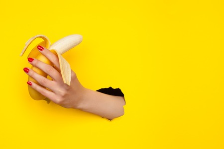 Anonymous hand holding bananaの写真素材
