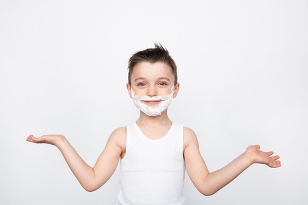 Boy with shaving foam on faceの写真素材