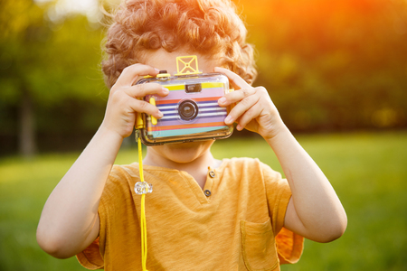 Youngster taking picture on green meadowの写真素材
