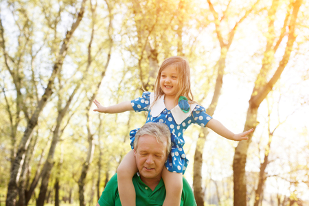Grandfather with girl on shouldersの写真素材