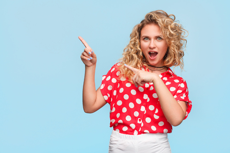 Blonde woman in red shirt making gesticulationの写真素材