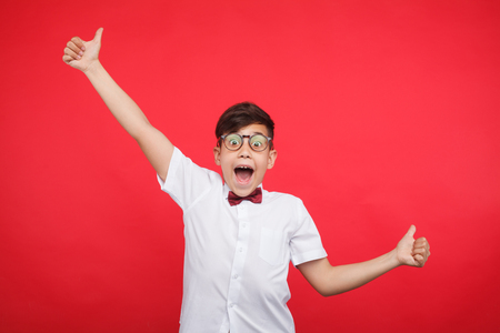 Cheerful boy gesturing on redの写真素材