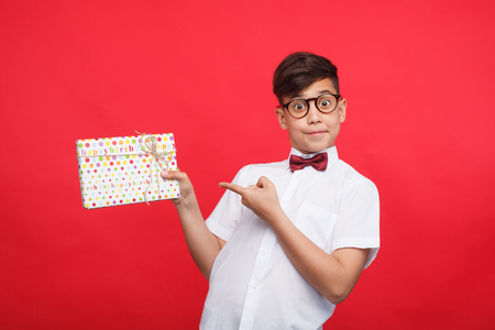 Expressive kid pointing at giftboxの写真素材