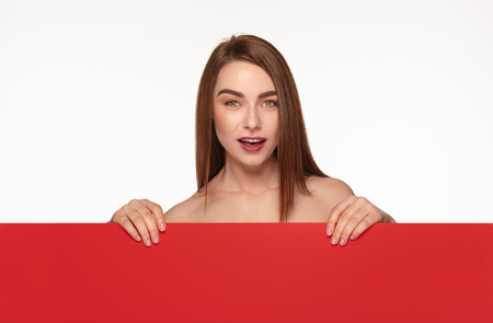 Nude woman covering with red cardboardの写真素材