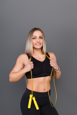 Cheerful woman posing with jumping rope