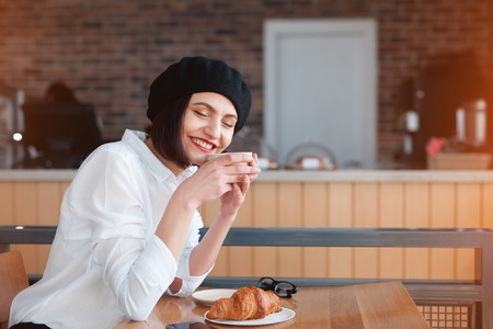 Lady in beret sitting in cafeの写真素材