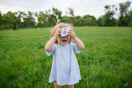 Little girl posing with photo cameraの写真素材