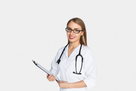 Female doctor wearing glasses holding clipboardの写真素材