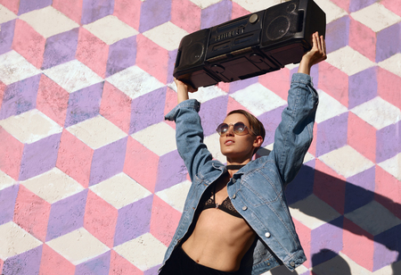 Stylish woman with boombox on streetの写真素材