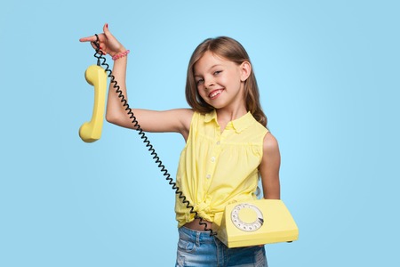 Charming girl posing with old phoneの写真素材