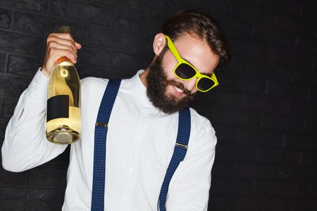 Excited trendy man with champagne