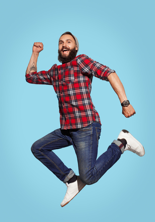 Cheerful bearded man jumpingの写真素材