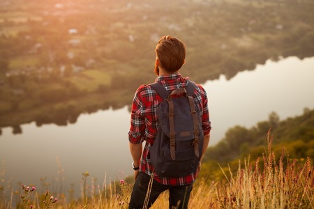 Hipster man with backpack on natureの写真素材