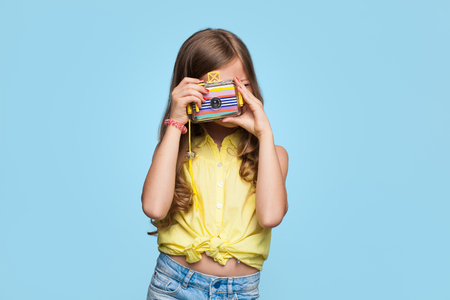 Little girl posing with photo cameraの写真素材