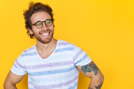 Smiling handsome man posing on yellowの写真素材