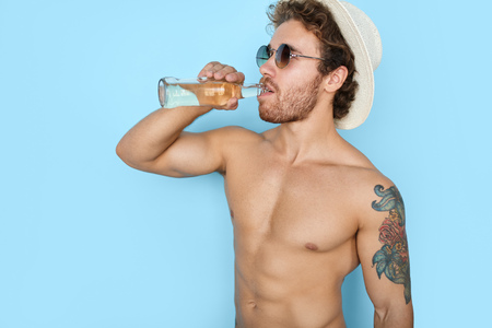 Muscular handsome man relaxing with drinkの写真素材