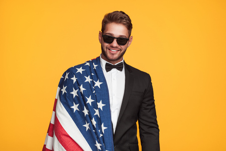 Smiling man in suit posing with flagの写真素材