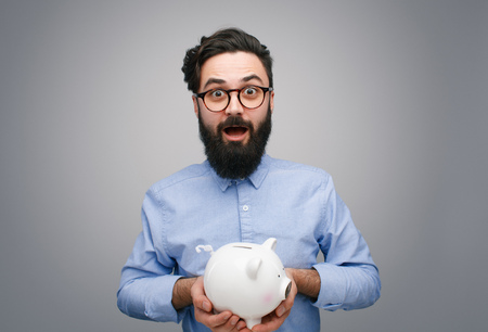 Content man with piggy bank on grayの写真素材