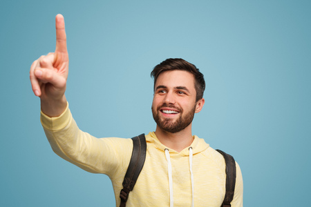 Smiling man indicating space with fingerの写真素材