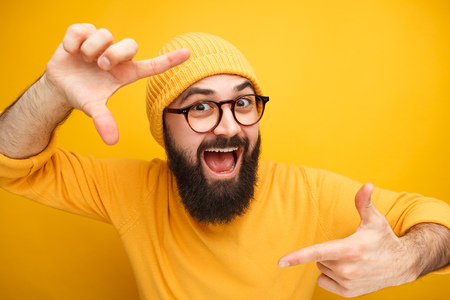 Excited guy taking photo with handsの写真素材