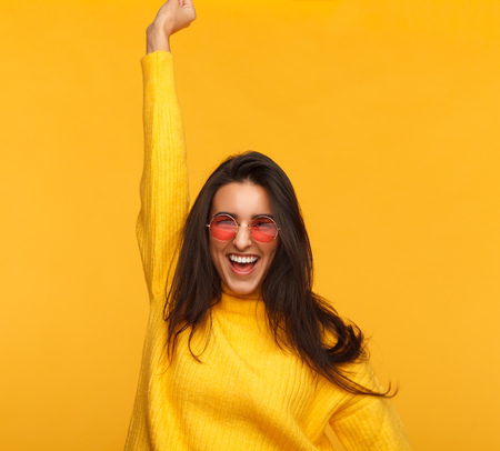 Cheerful hipster girl on yellowの写真素材