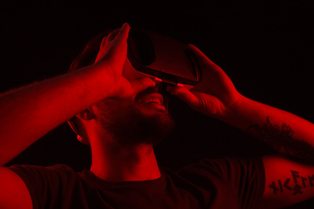 Cheerful man looking around in VR goggles