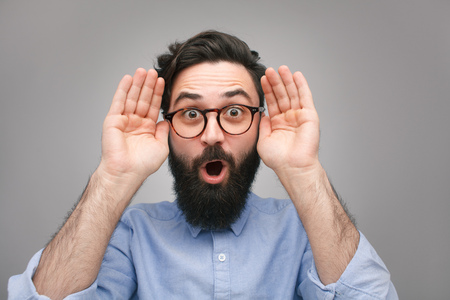Amazed bearded man with hands up