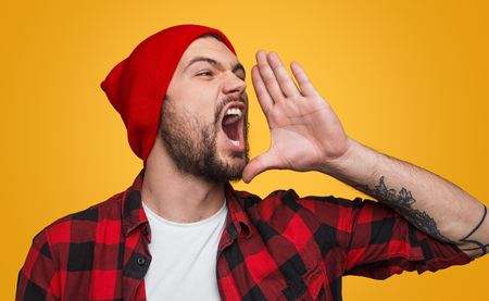 Expressive hipster announcing news loudlyの写真素材