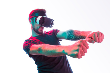 Gaming man in VR goggles on white