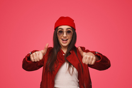 Happy bright girl with thumbs upの写真素材