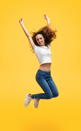 Casual slim woman in jump on yellow background