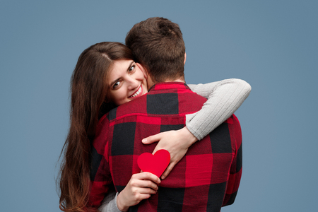 Pretty woman with heart hugging boyfriendの写真素材