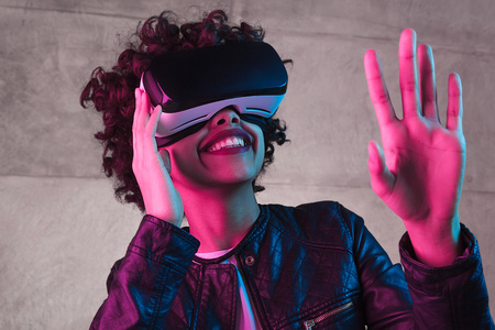 Smiling black teenager interacting with virtual realityの写真素材