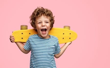 Cute boy with yellow skateboardの写真素材