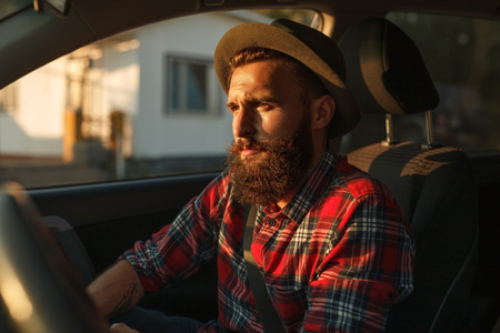 Hipster driving modern car on streetの写真素材