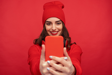 Stylish bright girl taking selfie with phoneの写真素材