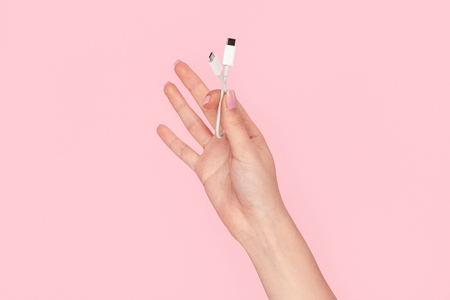 Woman showing white cable adapterの写真素材