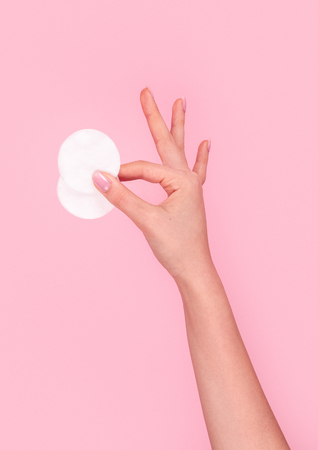 Crop hand showing cotton pads and gesturing OKの写真素材