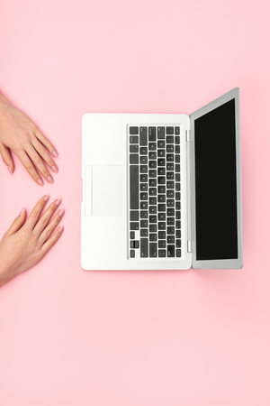 Woman with laptop on pink backgroundの写真素材