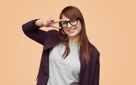 Playful chubby girl showing two fingersの写真素材