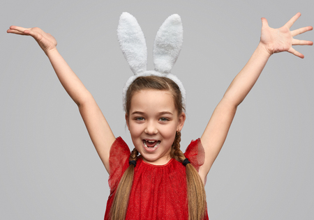 Bright girl in white ears holding hands upの写真素材