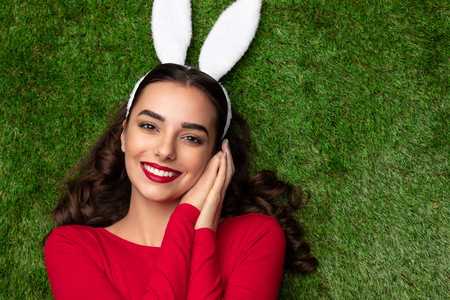 Pretty girl in bunny ears lying on meadowの写真素材