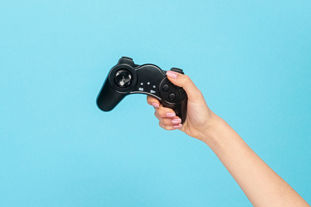 Girl with black gamepad on blue backdrop